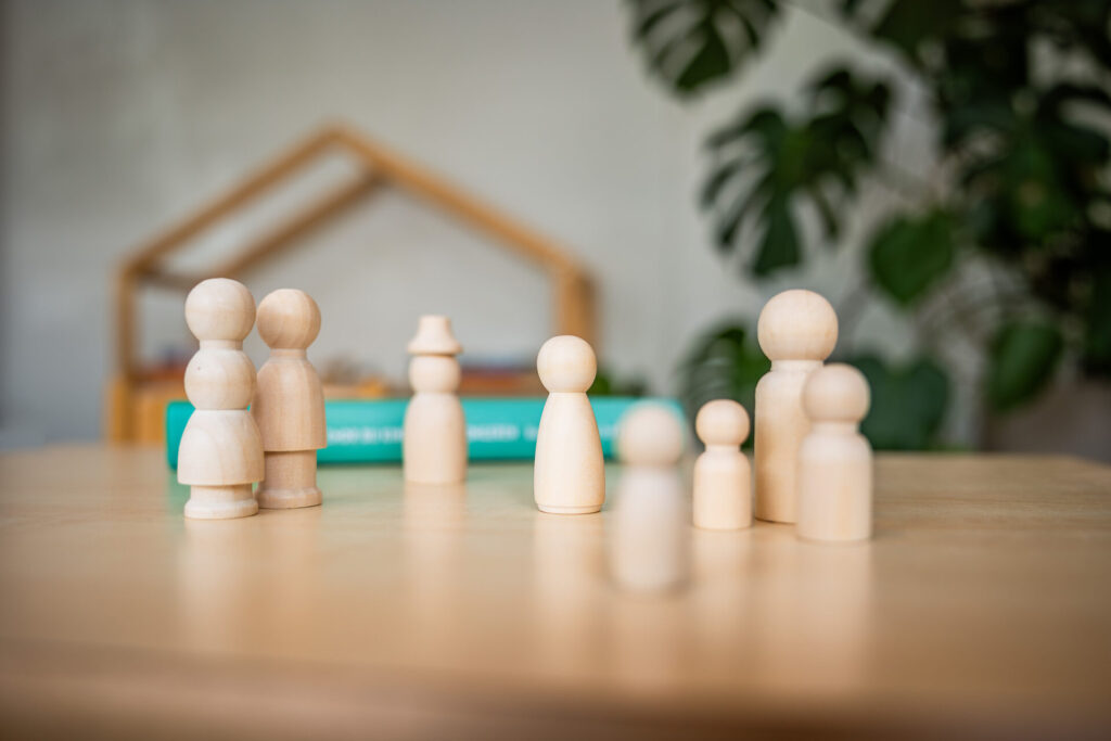 Houten poppetjes op tafel als symbool voor samen leren en reflecteren bij PRED